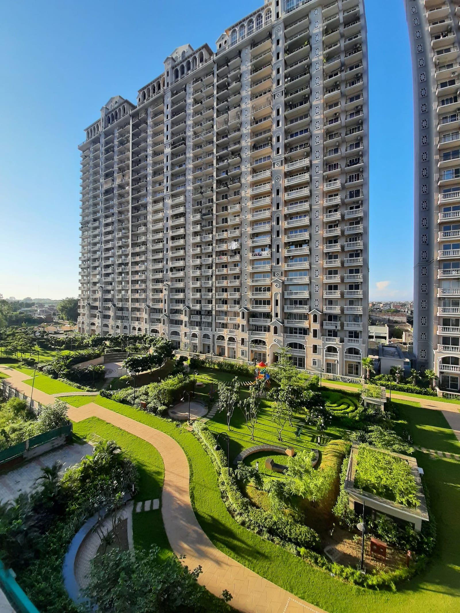 Photograph of an ATS Casa Espana tower above landscaped gardens and winding paths, Sector 121, Mohali