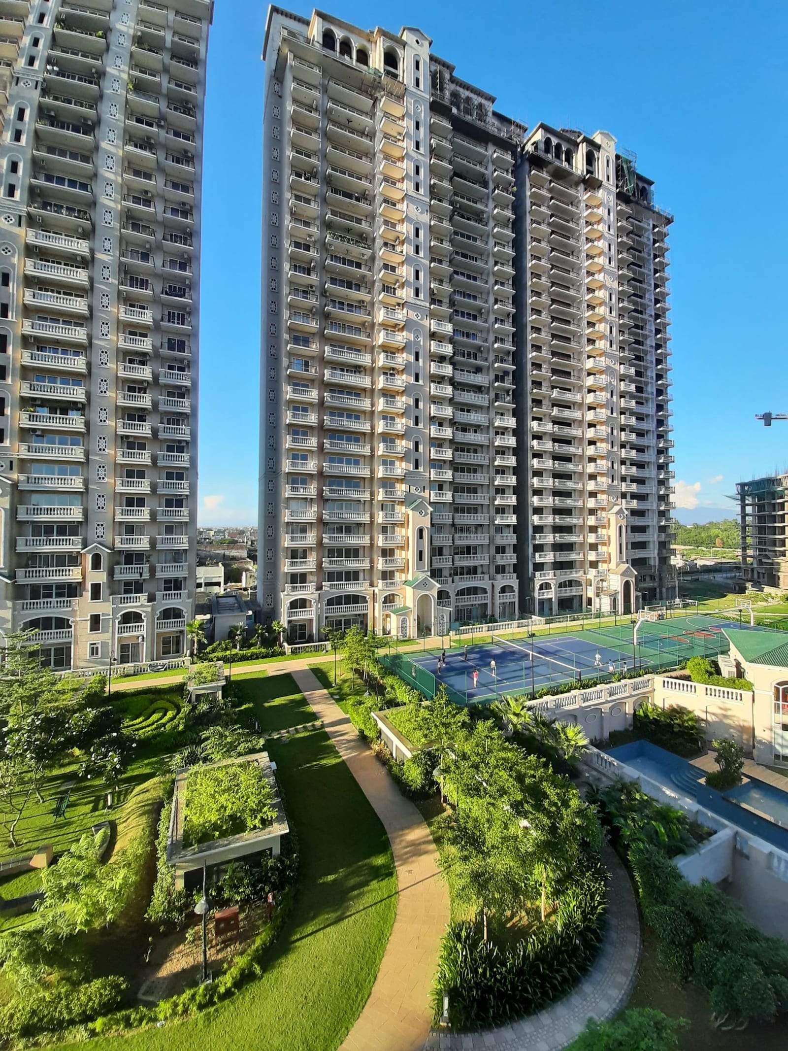Photograph of ATS Casa Espana towers with the tennis and basketball courts and gardens in front