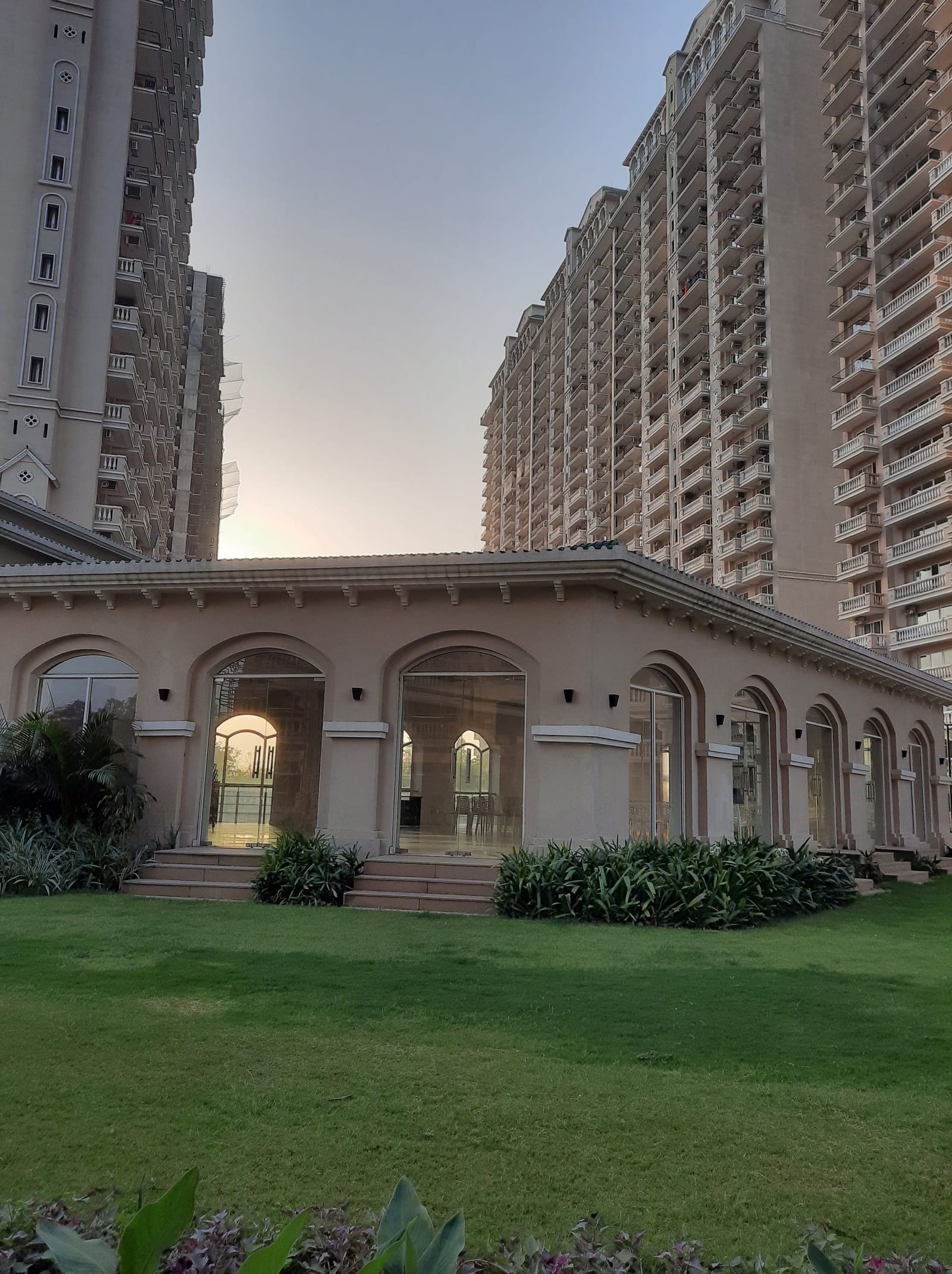Photograph of the arched clubhouse building at ATS Casa Espana with the towers behind
