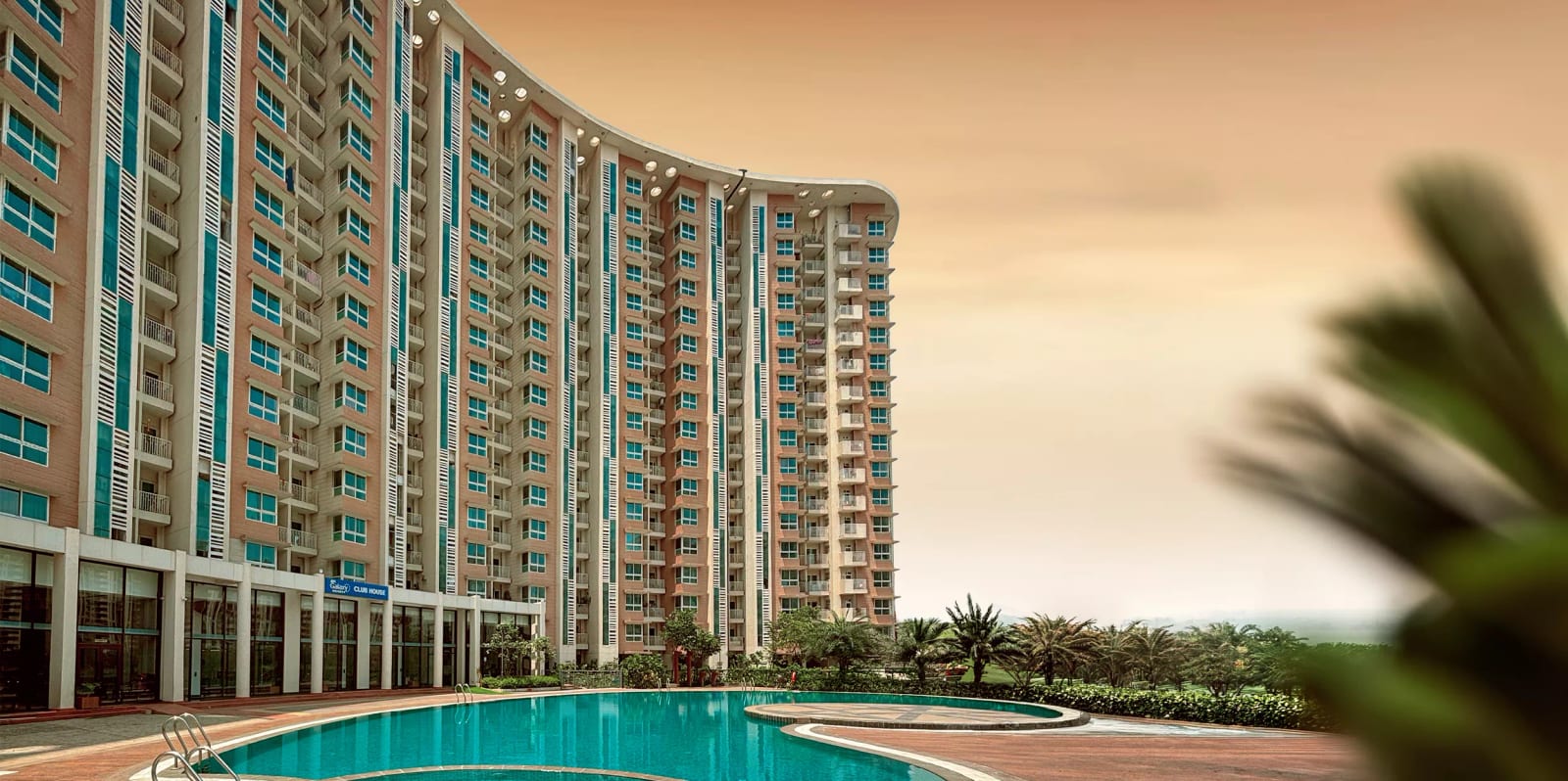 Photograph of the Galaxy Heights towers, Mohali, seen across the swimming pool, with the clubhouse at the base