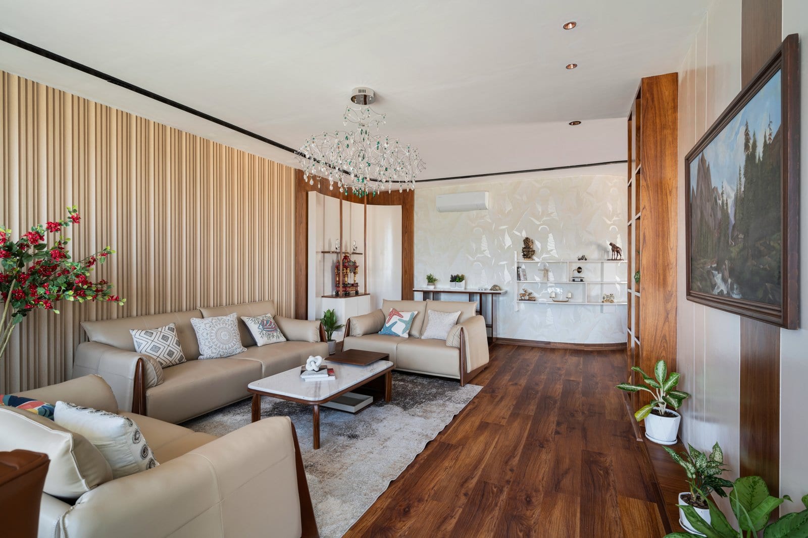 Living room of the sample apartment at The Wellness City, Rajpura, with beige sofas, fluted wall panelling and wooden flooring.
