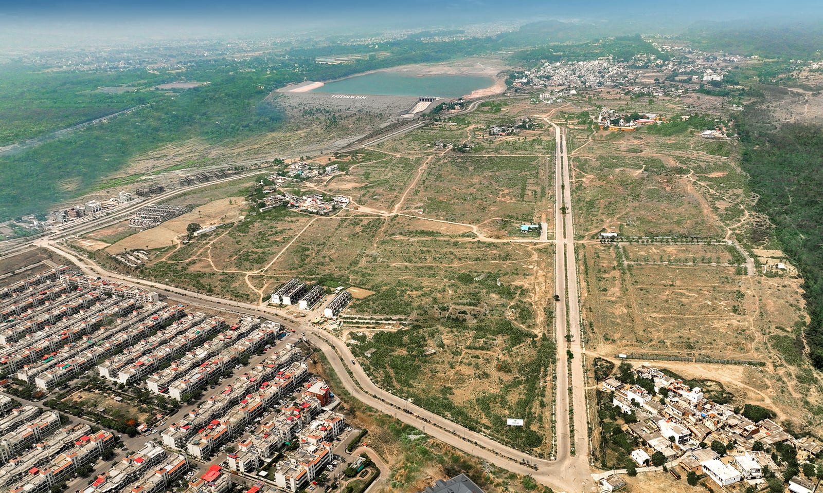 Aerial photograph of the Trident Hills site, Pinjore, with new roads laid out across the land and Kaushalya Dam in the distance, published by the developer in 2022