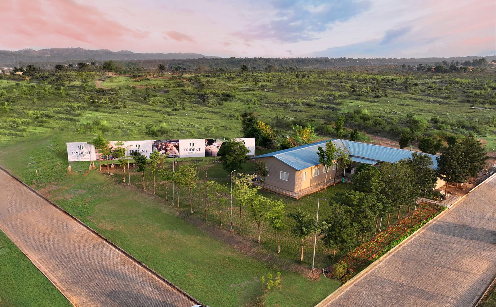 Aerial photograph of the Trident Realty site office at Trident Hills, Pinjore, with paved roads, young trees and hoardings