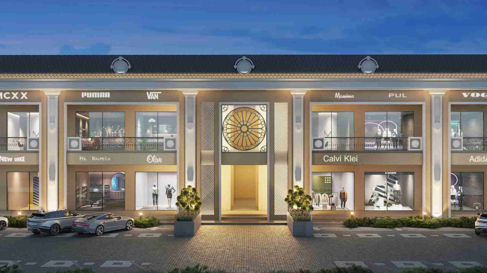 Dusk front elevation of the two-storey showroom facade at Victoria Street, Sirhind, with lit shopfronts, pilasters and a round rose-window feature above the central passage.